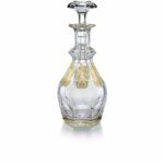 The HARCOURT EMPIRE decanter revisits the HARCOURT‚Äôs regal architectural form. The HARCOURT collection, created in 1841, is the oldest in the Baccarat archive and reputed for its iconic design. The HARCOURT EMPIRE decanter shares the same structure as the HARCOURT 1841 square whiskey decanter, but adorned with exquisite golden embellishment. Each flat cut side has gilded decorative shapes applied with a light hand, and a gold trim around the perimeter of both the decnater‚Äôs neck and base. The diamond-cut beveled stopper crowns the classical shape with geometric sophistication. The HARCOURT EMPIRE collection, a showcase of sparkling lucid crystal complemented by graceful gold, also includes a wine glass, highball glass, and champagne flute. Baccarat‚Äôs Rivoli stemware collection has gilded features as well.
