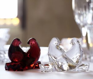 DOVES designed by CLAUS HARTUNG. Their silhouettes interweave in concert with one another, creating an appealing symmetry. Designed by CLAUS HARTTUNG for Baccarat, the grace and beauty of these two birds is evoked through the precision of the craftsmanship, from their slender bills to the detailing on their splayed feathers. Nimbly rendered, the love between them is easily perceptible. These doves are a perfect gift that tenderly symbolizes your devotion to your beloved. This affectionate duo of doves is also available in clear crystal.