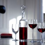 DYONISOS decanter designed by VAN DAY TRUEX. Decanting a young wine allows its undertones to flourish, and decanting may also be a fitting option for an older wine that has yet to attain complete maturity. The DIONYSUS decanter is not only a vehicle that helps the wine reach its full integrity; it is also a stunningly crafted piece. The minimalist silhouette resembles a clear crystal Bordeaux wine bottle. The poise of the slender neck morphs gracefully into the base, and the stopper caps off the sleek form with a perfectly rounded globe of Baccarat clear crystal. Designed by VAN DAY TRUEX, the understated shape matches seamlessly with any Baccarat bar and stemware set.