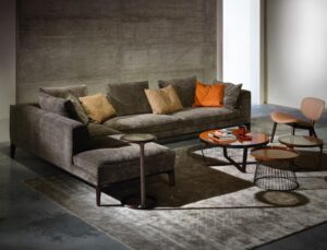 Don Giovanni Sofa by Giuseppe Casarosa. Create a classic and contemporary look by choosing refined materials and well-balanced volumes. The vast range of terminal and angular units, chaise longue and poufs, along with two different depths for some elements, allows various solutions. Internal structure made in plywood, base in solid American walnut, upholstered seat and back-rest covered in fabric, leather or natural leather, leg tips in brass. To complete the collection a console in two dimensions and a side table. Accessories necessary to optimize and personalize the space.