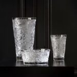 MERLES ET RAISINS bowl. In 1928, RENÉ LALIQUE designed the MERLES & RAISINS decorative panels, originally in created in pressed glass on a silver background and adorned the Cuban mahogany woodwork of the legendary Orient Express. Today, the Lalique Studio reinterprets this emblematic creation, in new expressions through vases and a bowl. The precious cultural heritage of the House thus comes to life in very contemporary shapes. Blackbirds with finely chiseled plumage indulge in an abundance of sweet grapes while the vines create an exceptional rhythm throughout a perfectly balanced composition. The richness of the decor conveys a sensation of profusion and of abundance. Highlighted by the purity of satin-finished crystal, signature of the House, these decorative objects brilliantly illustrate the timeless character of Lalique creations.