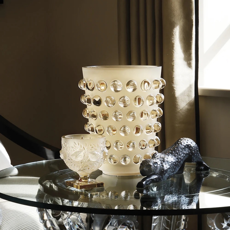 MOSSI XXL vase designed by REN√â LALIQUE.  The kaleidoscopic effect of the MOSSI Vase is both a stroke of creative genius and a feat of technical mastery. REN√â LALIQUE designed this flagship piece in 1933. His original choice of material was plain glass, which the company has transformed into the vibrant intensity of crystal. A genuine interior design accessory of modernity, the MOSSI plays on the contrast between the brilliance of its cabochons and the frosting of its base. It has been recently reinterpreted in this extra large size.