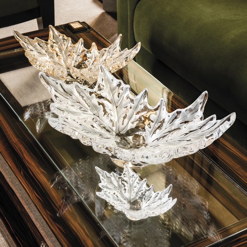 CHAMPS-ÉLYSÉES bowl.The spectacular rows of plane trees lining “the most beautiful Avenue of the World” inspired the design of the finely engraved crystal leaves that adorn the Champs-Elysées bowl, designed by MARC LALIQUE in 1951. This sculpture of light and crystal captures the very essence of Paris.   This iconic artwork is now issued in a grand and small version. One of the grand versions is transformed by the manufacturing technique of double gathering.