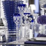 Crystal glasses TSAR. Created for Tsar Nicholas II, this clear crystal glass - overlaid in coloured crystal with a high stem, a scalloped base, and diamond and palm leaf decorations - is spectacular. In a range of three different colours, this exceptional set won over many aristocrats in the Imperial Court and is to this day a reflection of the House of Baccarat's excellence. Glasses in three different sizes and champagne flutes are available, for an exceptional, royal meal.