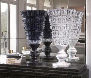 NEW ANTIQUE vase by MARCEL WANDERS STUDIO. This exquisite hand-blown clear crystal vase mounted on a stylish white marble base is available in a limited edition of 99 numbered pieces. MARCEL WANDERS STUDIO has drawn inspiration from classic pieces of decorative art and from his own Baroque world in creating a new collection of vases which is appropriately named NEW ANTIQUE. Each vase is blown and decorated with deep geometric cuts before being mounted on a black Italian marble base, much like a trophy. This clear crystal vase, decorated inside with black lacquer and criss-cross bevel cuts, is available in a limited edition of 99 numbered pieces signed Baccarat and MARCEL WANDERS STUDIO. It is an exquisite piece that will lend sumptuous splendour to any room.