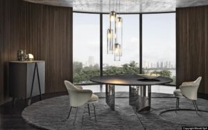 WEDGE DINING TABLE by NENDO, designed in 2019. WEDGE explores the concept of a table with a strong graphic style, offering both a dining room and coffee table version. In the dining table, the bulky look created by the solid sculptural masses of the semi-circular legs of wedge contrasts with the lightweight feet, which culminate in an oblique chisel tip shape. The entire volume of the table, hosting the large top, appears to become weightless and leans lightly on the tips of the legs, challenging the law of gravity. The element of surprise is even stronger in the version with barrel-shaped glass top, the surface of which reveals the semi-circles of the supports, positioned in a purposely irregular formation.